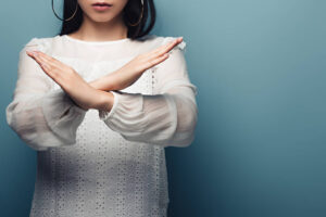 Woman crossing arms to make an X gesture