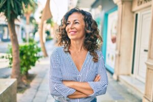 Middle age hispanic woman smiling happy walking at the city