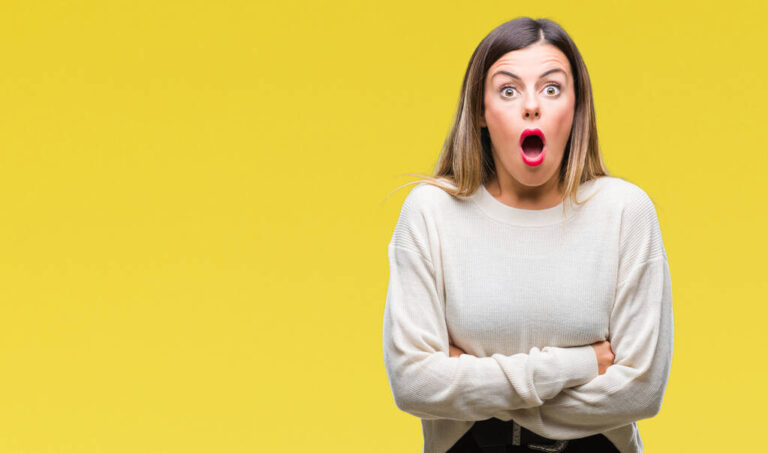 Young beautiful woman casual white sweater over isolated background afraid and shocked with surprise expression, fear and excited face.