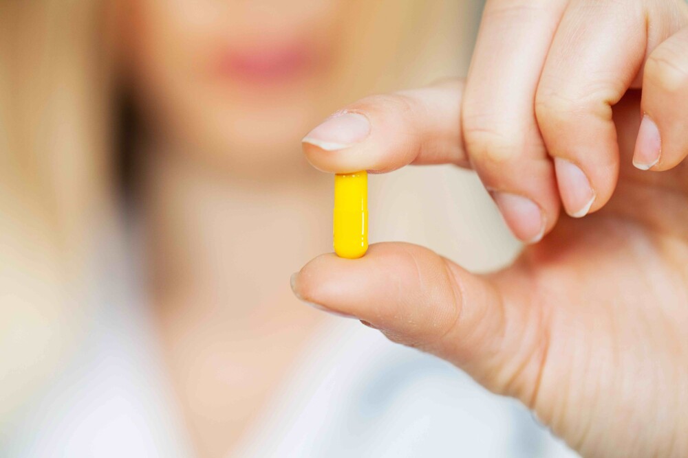 woman holding a pill