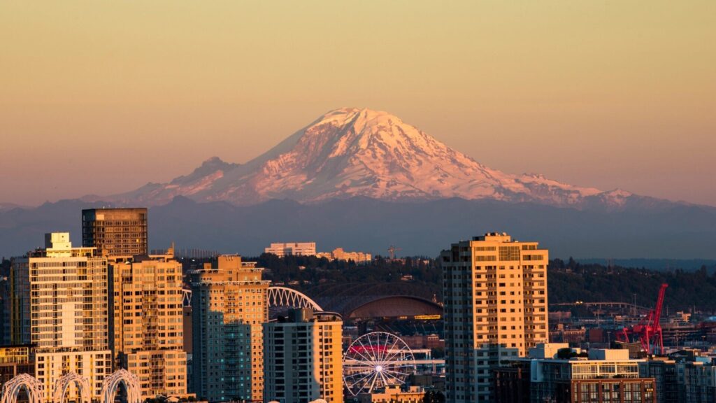 Seattle skyline at sunset with Mount Rainier rising snow-capped in the background