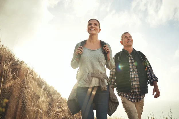 Smiling couple with backpacks hiking outdoors
